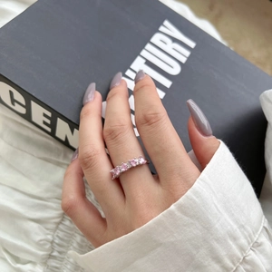 Gros plan d'une bague en argent S925 avec cinq zircons roses en forme de cœur au doigt