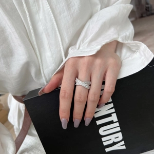 Gros plan d'une bague en argent S925 avec design en X croisé et zircons scintillants