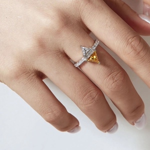 Détail d'une bague en argent S925 avec zircons triangulaires jaune et blanc sur la main