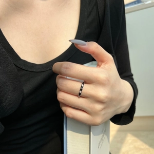 Close-up of S925 sterling silver ring with black enamel and sparkling zircon on a finger