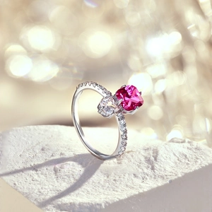 Macro d'une bague en argent avec pierre rose taille coussin et zircons transparents
