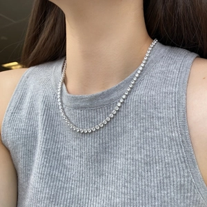 Gros plan d'un collier tennis en argent 925 et oxydes de zirconium de 4mm sur un cou