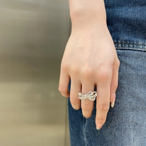 Macro detail of a silver S925 bow ring with sparkling zircon inlays on a model finger