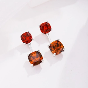 Macro detail of square-cut red and orange stones set in S925 sterling silver earrings