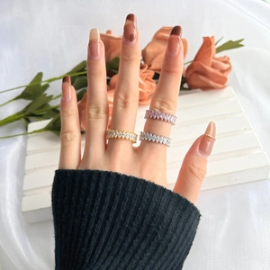 Détail de trois bagues éternité avec taille marquise en finitions argent, or et rose