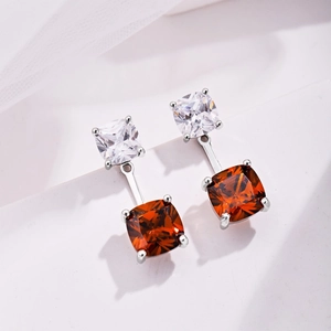 Close-up of S925 sterling silver earrings with square orange and clear zircon stones