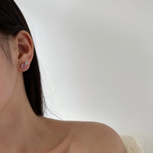 Detailed close-up of heart-shaped pink zircon earrings on model for a romantic look