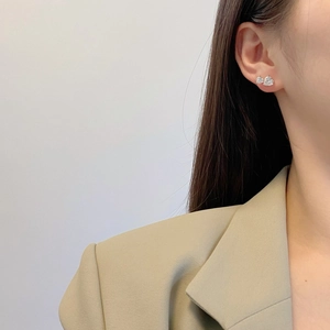 Close-up of S925 silver heart stud earrings with double cubic zirconia on model ear