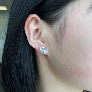 Detail of S925 silver heart stud earrings with cubic zirconia on a female model's ear