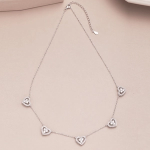 Detail of S925 sterling silver chain featuring five hollow heart pendants with zircons