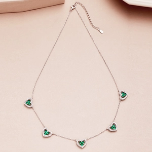 Close-up of S925 sterling silver necklace with five heart pendants and green zircons