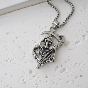 Macro shot of silver retro Grim Reaper pendant with box chain on textured background