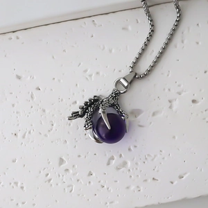 Detailed close-up of a dragon claw pendant holding a purple orb on a silver square chain