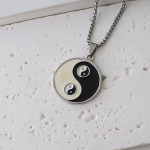 Detailed view of silver Tai Chi Yin Yang pendant with black and white enamel finish
