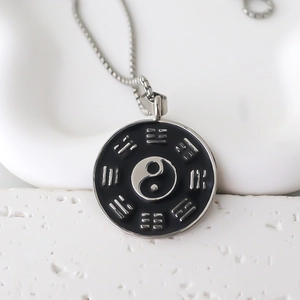 Détail macro du pendentif Yin Yang Tai Chi avec symboles Bagua sur chaîne argent