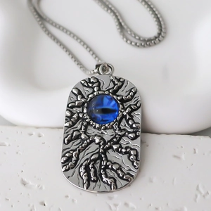 Détail du pendentif gothique en relief argenté avec œil bleu et chaîne à mailles