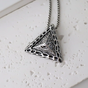 Macro view of stainless steel pyramid pendant featuring the Eye of Providence and mesh texture