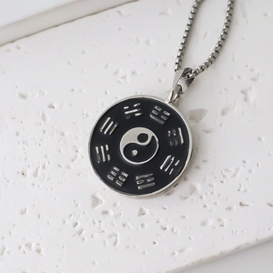 Gros plan du pendentif Yin Yang Tai Chi avec symboles Bagua sur chaîne maille miroir