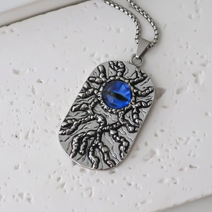 Détail macro du pendentif argenté avec texture vintage et pierre d'oeil bleu