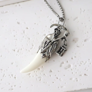 Vue macro du pendentif faucheuse gothique avec griffe en résine sur chaîne argent