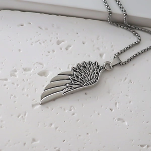 Macro shot of retro feather wing pendant with detailed texture on box chain