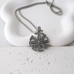 Retro Slavic Kolovrat sun wheel necklace with intricate Celtic knot patterns on white stand