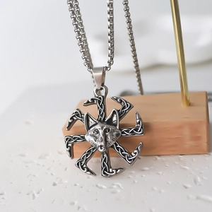 Viking wolf head pendant necklace with Celtic sun wheel design on a gold display stand
