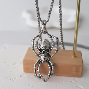 Gothic spider skull pendant necklace in silver alloy on a metal display stand