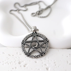 Close-up of vintage silver pentagram pendant with moon and Celtic knots on stone