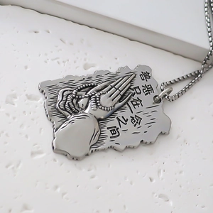 Détail du pendentif en alliage avec caractères chinois gravés et motif de mains en prière