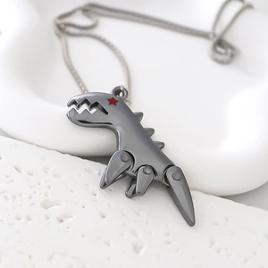 Macro detail of mechanical dinosaur pendant with red star eye and industrial steel finish