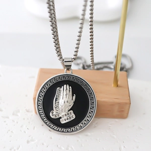 Polished silver praying hands medallion necklace with Greek key border and box chain