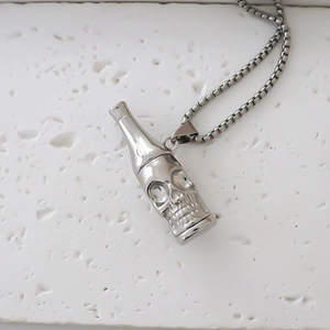 Detail of silver bottle pendant with skull relief on box chain over white stone texture