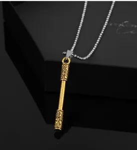 Macro detail of golden staff pendant with traditional patterns on black jewelry box