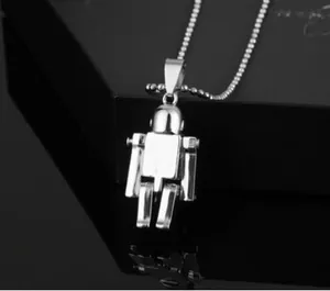 Vue macro du pendentif robot argenté avec structure mécanique sur une chaîne à billes