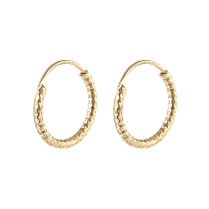 Close-up of golden hoop earrings with intricate diamond-cut honeycomb texture