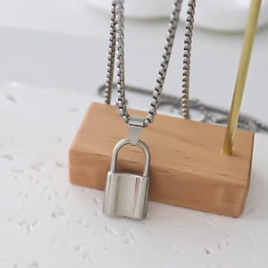Industrial style silver box chain necklace featuring a polished metal lock pendant