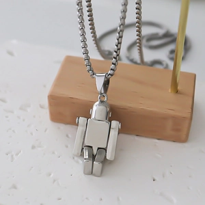 Collier pendentif robot argenté poli avec chaîne box sur fond de pierre minimaliste
