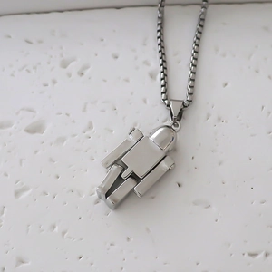 Détail macro du pendentif robot argenté montrant les articulations mobiles sur une chaîne