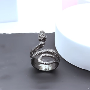 Detailed macro view of gunmetal snake ring with intricate scale textures on a stone base