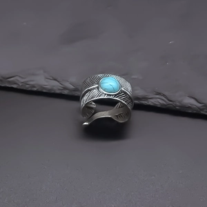 Vista dettagliata dell'anello in argento con piuma e pietra di turchese blu centrale