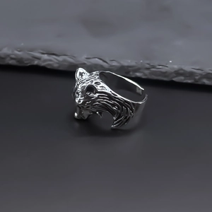 Close-up of vintage wolf head ring with detailed silver punk textures and open band style