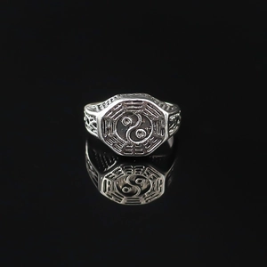 Macro shot of silver-tone alloy ring featuring traditional Tai Chi and Bagua engravings