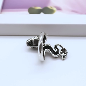 Detailed view of silver dragon-tail wrap ring with oxidized finish and polished edges