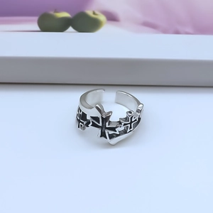 Close-up of gothic silver cross ring with black enamel details and adjustable band
