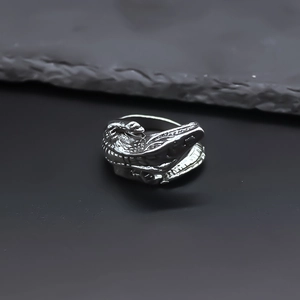 Macro detail of silver metal crocodile ring showing intricate scale textures and cool tones