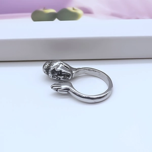 Close-up of vintage silver Buddha head ring with prayer hands in ethnic style