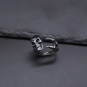 Close-up of vintage skull and eagle claw ring with a distressed silver punk aesthetic