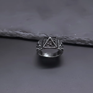 Detailed close-up of retro punk ring featuring pyramid relief and gothic cross textures