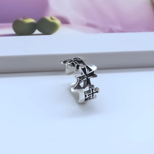 Macro detail of gothic cross pattern ring with black hollow-out antique metal finish
